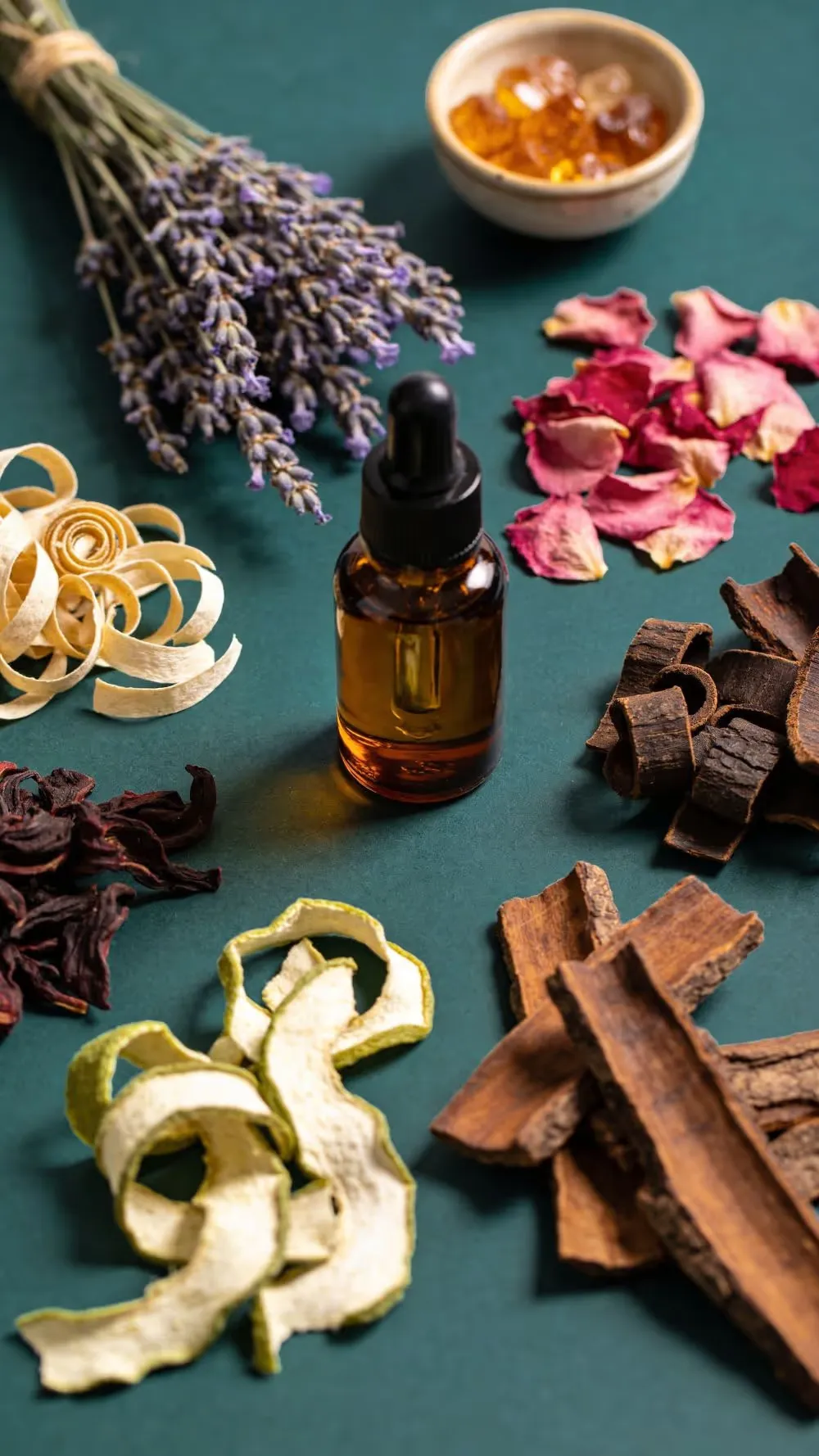 عبوة زيت عطري محاطة بمكوّنات صناعة العطور